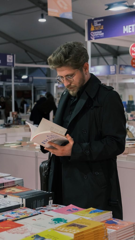 Adult male browsing and reading books at an indoor bookstore event